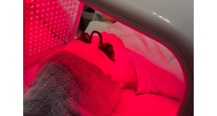 Beauty Point 3:LEDフェイシャル施術中の様子。ハーブピーリング後、赤色LEDライトを顔に照射しながらリラックスしている女性